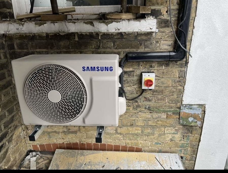 Wall mounted air conditioning condenser unit installed with an external isolator switch