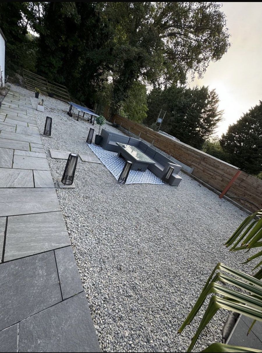 Landscaped garden with porcelain paving, decorative gravel and a stone fire pit