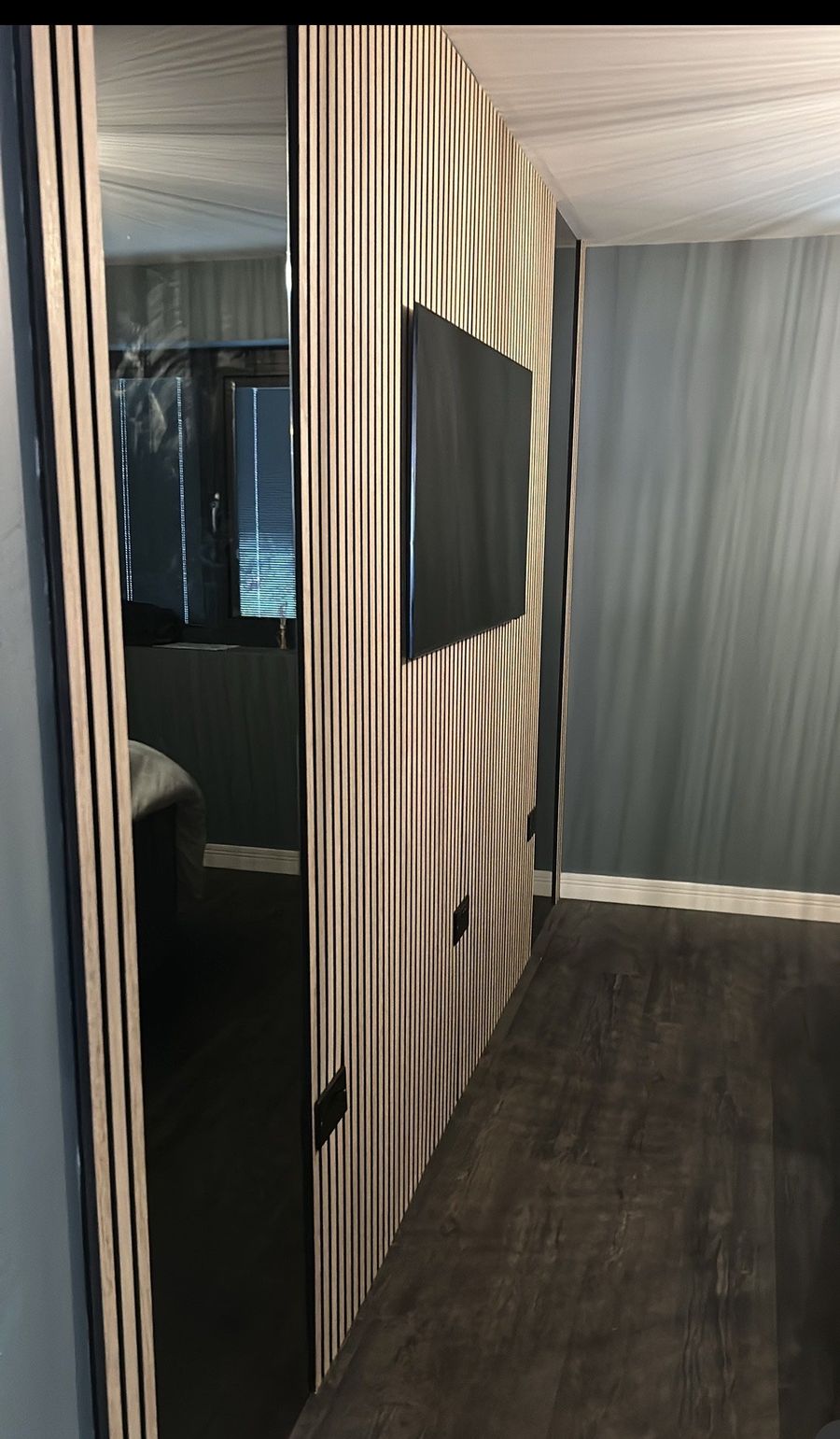 Slatted timber feature wall and dark flooring in a finished hallway renovation