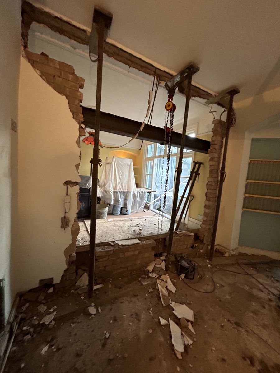 Internal wall stripped back to brickwork with acrow props supporting a new steel beam