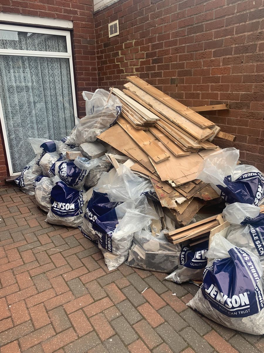 Bagged waste and stripped timber stacked outside a property ready for removal