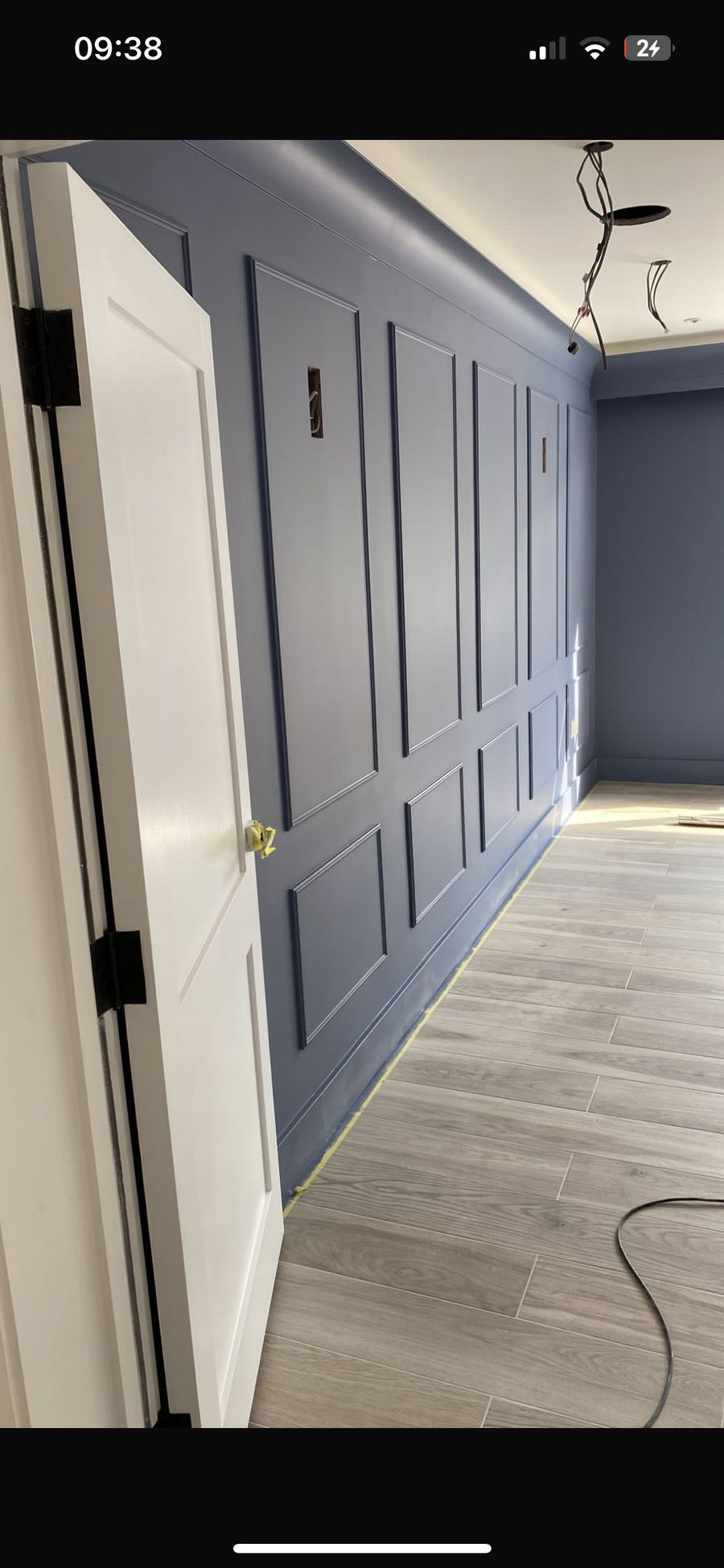 Blue painted shaker panelling fitted along a hallway with new oak flooring